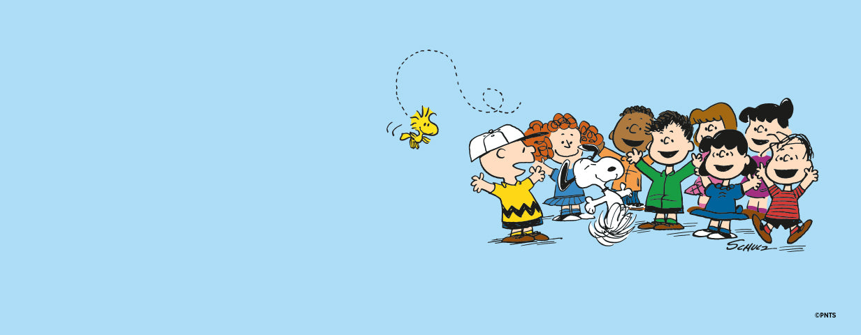 A cheerful Peanuts comic scene featuring Charlie Brown, Snoopy, Woodstock, and several friends including Lucy, Linus, Peppermint Patty, and Franklin, all gathered joyfully on a blue background. Woodstock flies above them in a looping path while Snoopy dances with excitement.