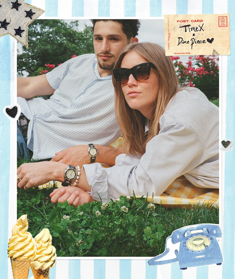 A stylish couple lounges on a picnic blanket in a grassy park. Both are wearing vintage-style Timex x Dimepiece watches with black straps and cream dials.