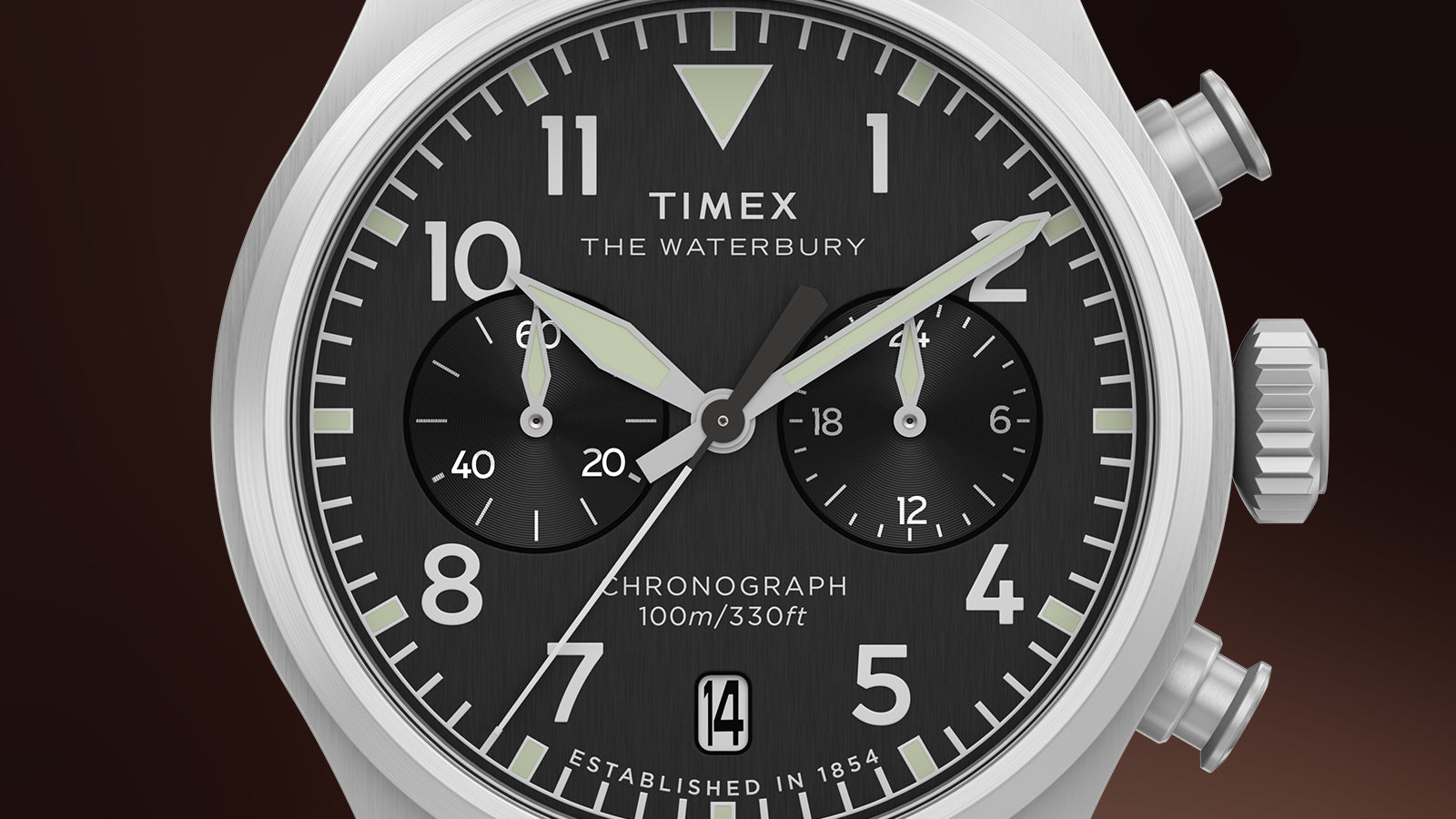 Close-up of the Timex Waterbury Ace Chronograph dial, highlighting luminous hands, chronograph subdials, bold Arabic numerals, and a date window at 6 o’clock.
