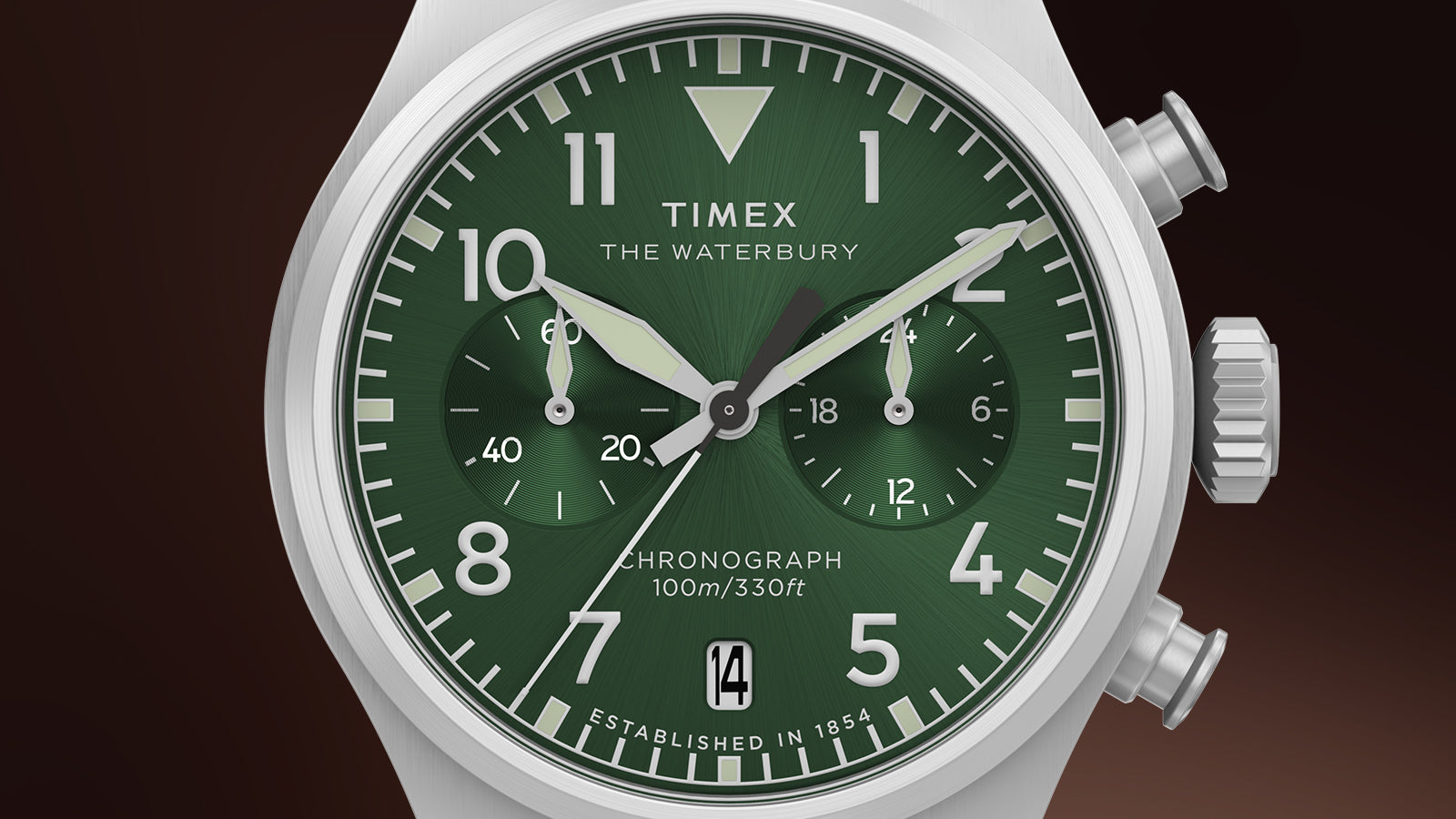Close-up of the Timex Waterbury Ace Chronograph dial in deep green, featuring bold Arabic numerals, luminous hands, chronograph subdials, and date window at 6 o’clock.