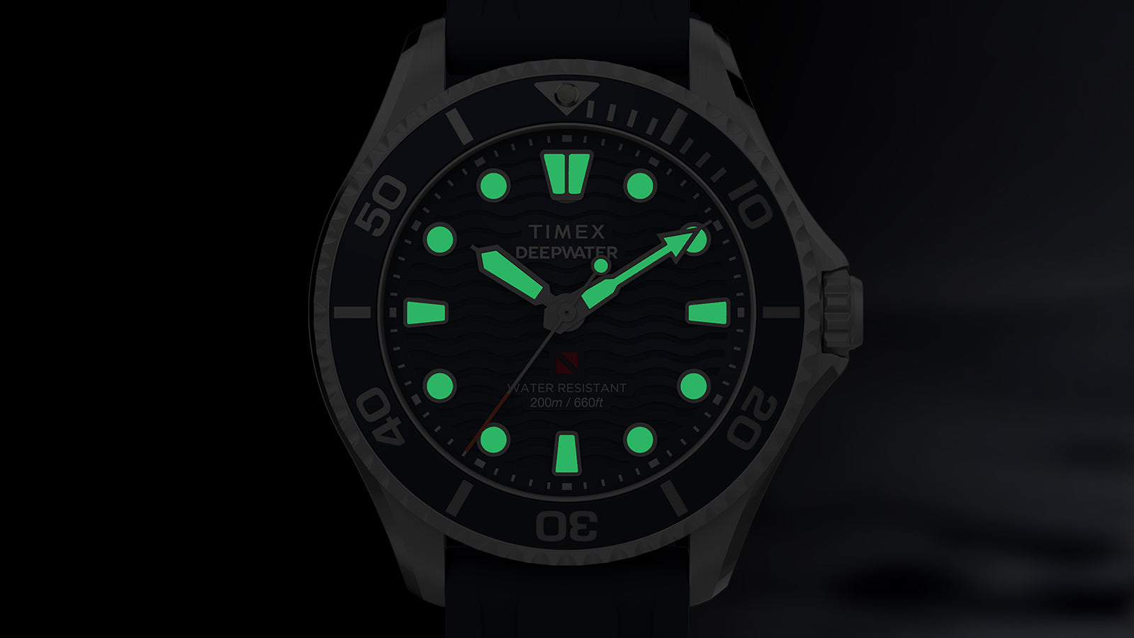 Front view of the Timex Deepwater Meridian 200 in the dark, with luminescent markers and hands glowing green.