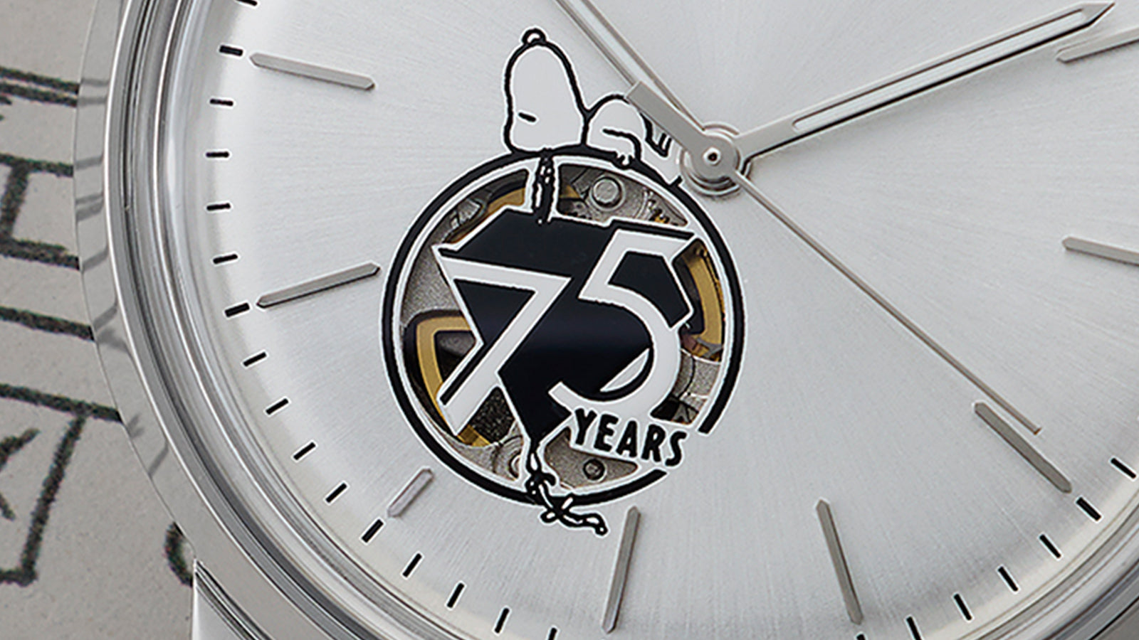 Close-up of the Timex x Peanuts® Marlin® Automatic watch dial, highlighting Snoopy illustration, bold “75 Years” logo shaped like a kite, and visible movement through the open-heart design.