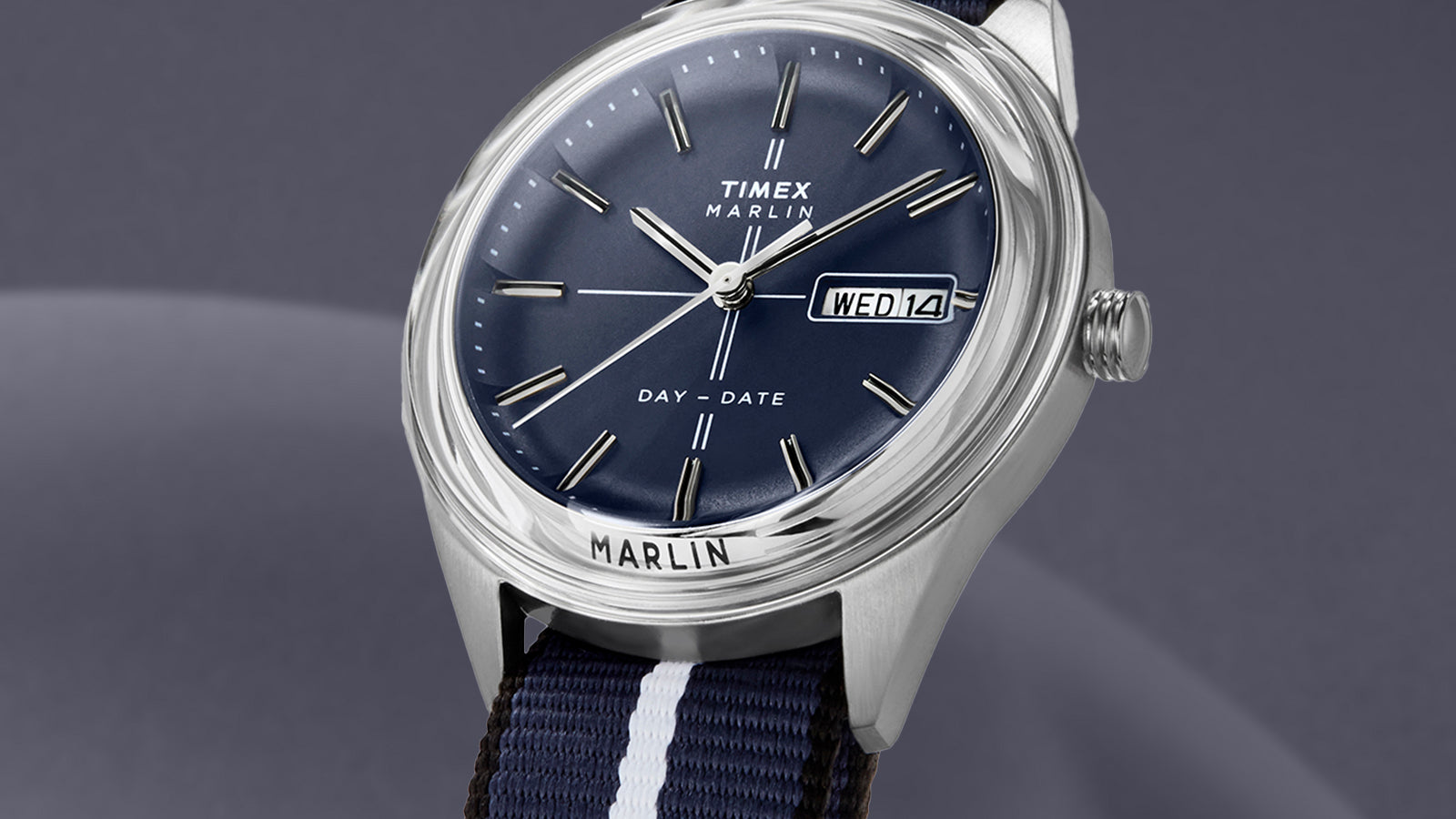 Close-up angled view of the Timex Marlin® Jet Quartz watch, emphasizing the blue dial, stainless-steel case, domed crystal, and day-date display at 3 o’clock.