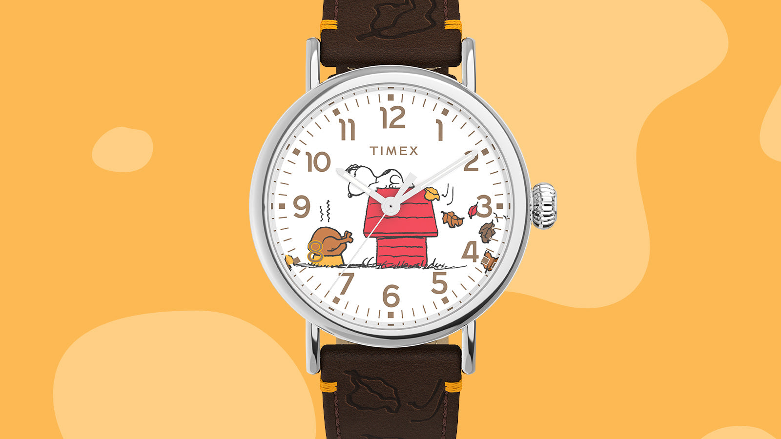 Close-up of the Timex x Peanuts® Standard Thanksgiving Edition watch dial, featuring Snoopy and Woodstock among autumn leaves beside a red doghouse, with brown numerals and white background.