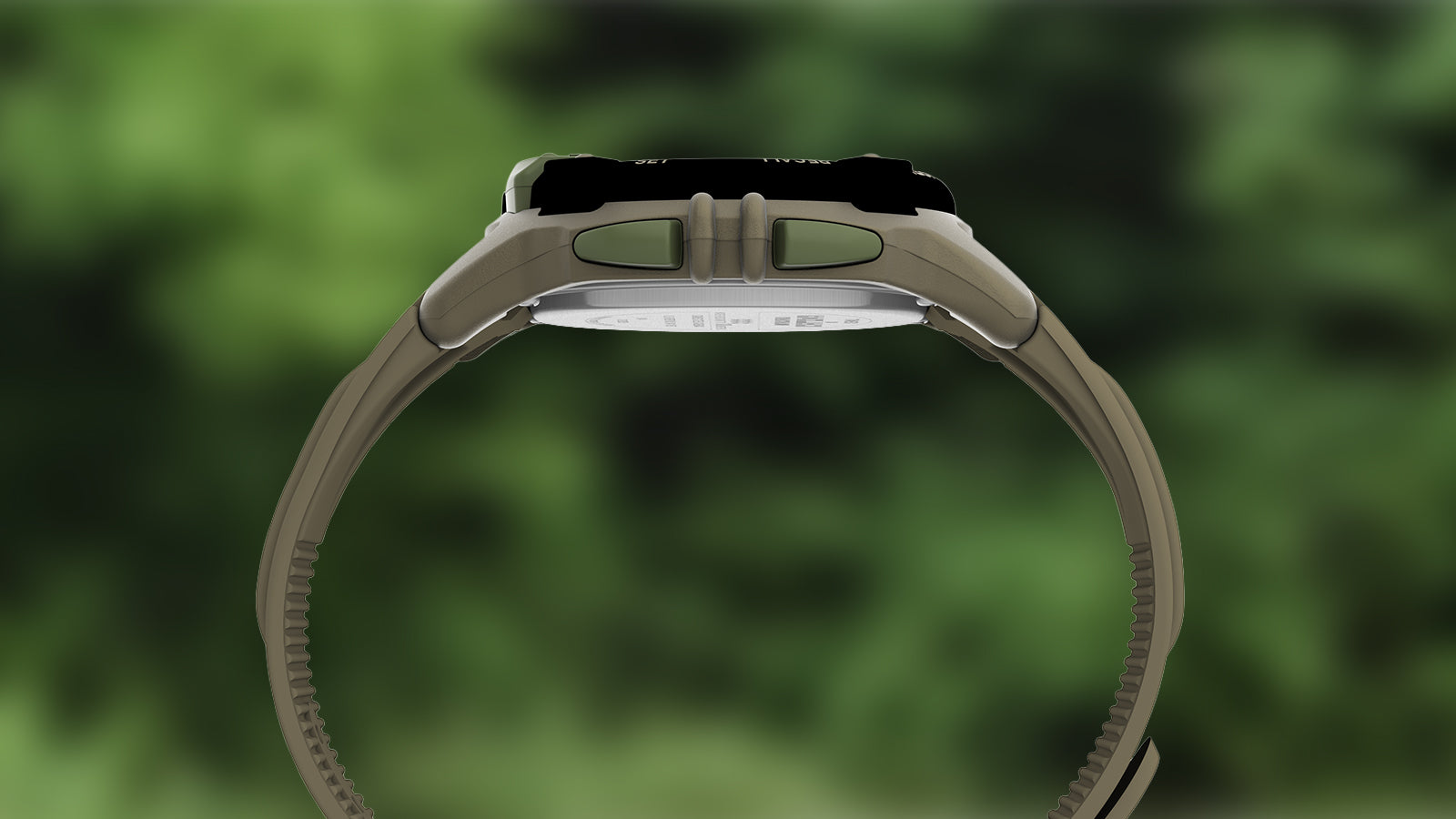 A side profile of the TIMEX® IRONMAN® Flix x Huckberry digital watch, showcasing its rugged case thickness, side function buttons, and contoured khaki strap for durability and comfort.