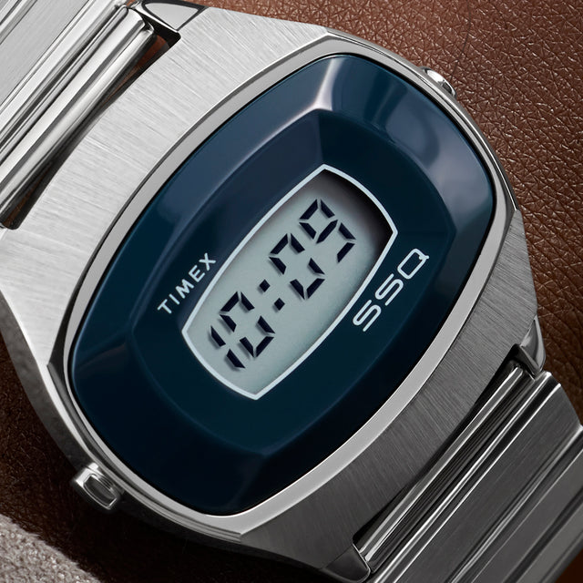 Close-up of the Q Timex® 1975 SSQ Digital Reissue dial showing the rectangular digital display framed by a deep blue bezel and the SSQ logo beneath the screen.