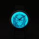 Timex Weekender Day of the Dead watch dial glowing in the dark with INDIGLO® backlight, revealing a bright blue sugar skull and floral details.