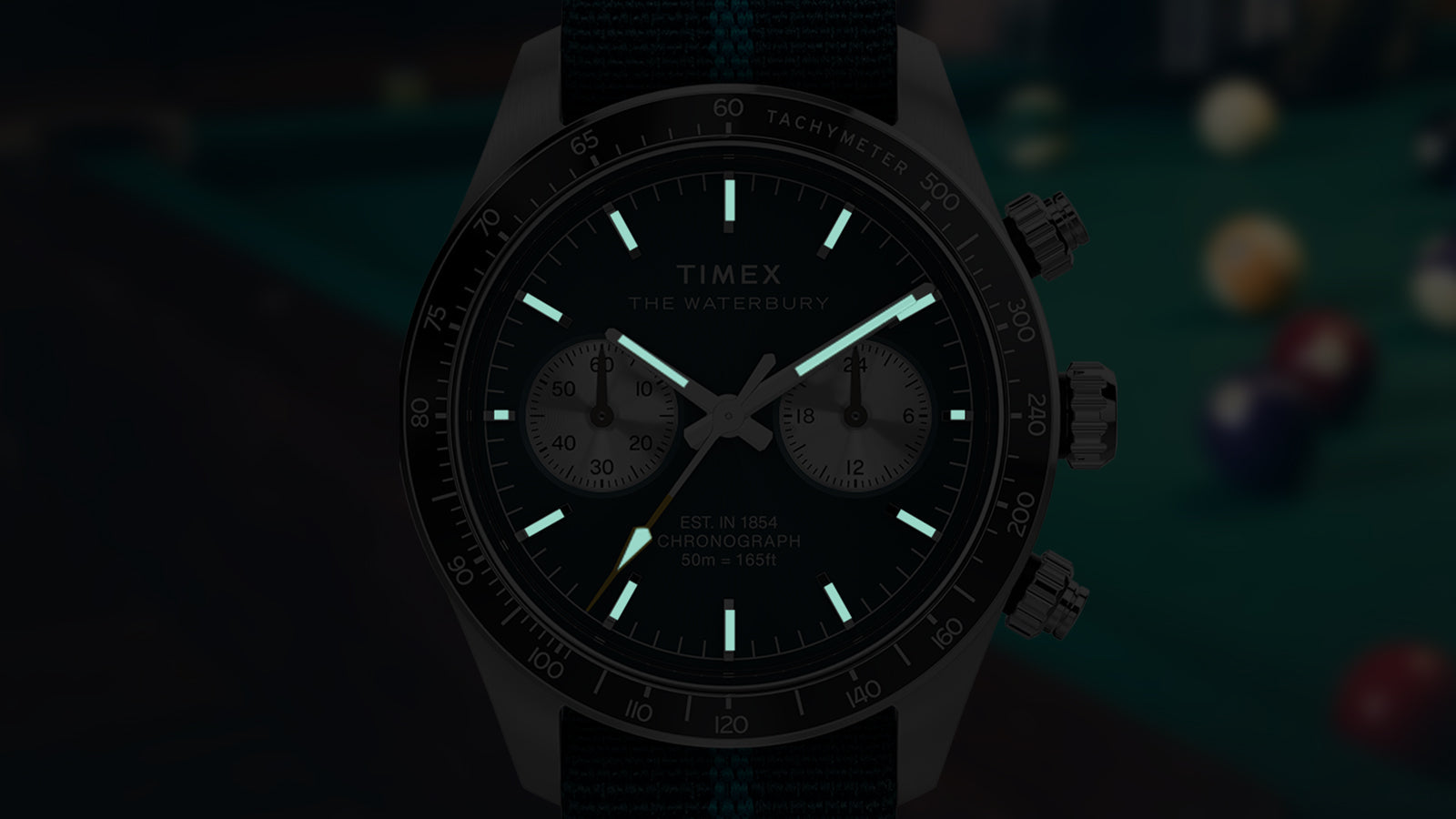 Timex Waterbury Heritage Chronograph with INDIGLO® backlight illuminating hands and hour markers in the dark.