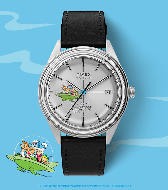 Close-up of Timex Marlin Jet Automatic watch featuring The Jetsons spaceship on the dial, displayed on a light blue background with cartoon Jetsons family illustration at the bottom.