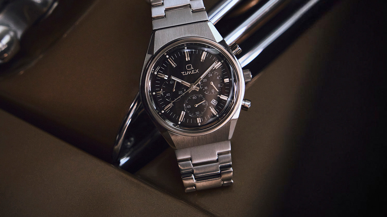 Close-up of Q Timex Falcon Eye Chronograph featuring a black dial with silver-tone markers, date window, and detailed chronograph subdials.