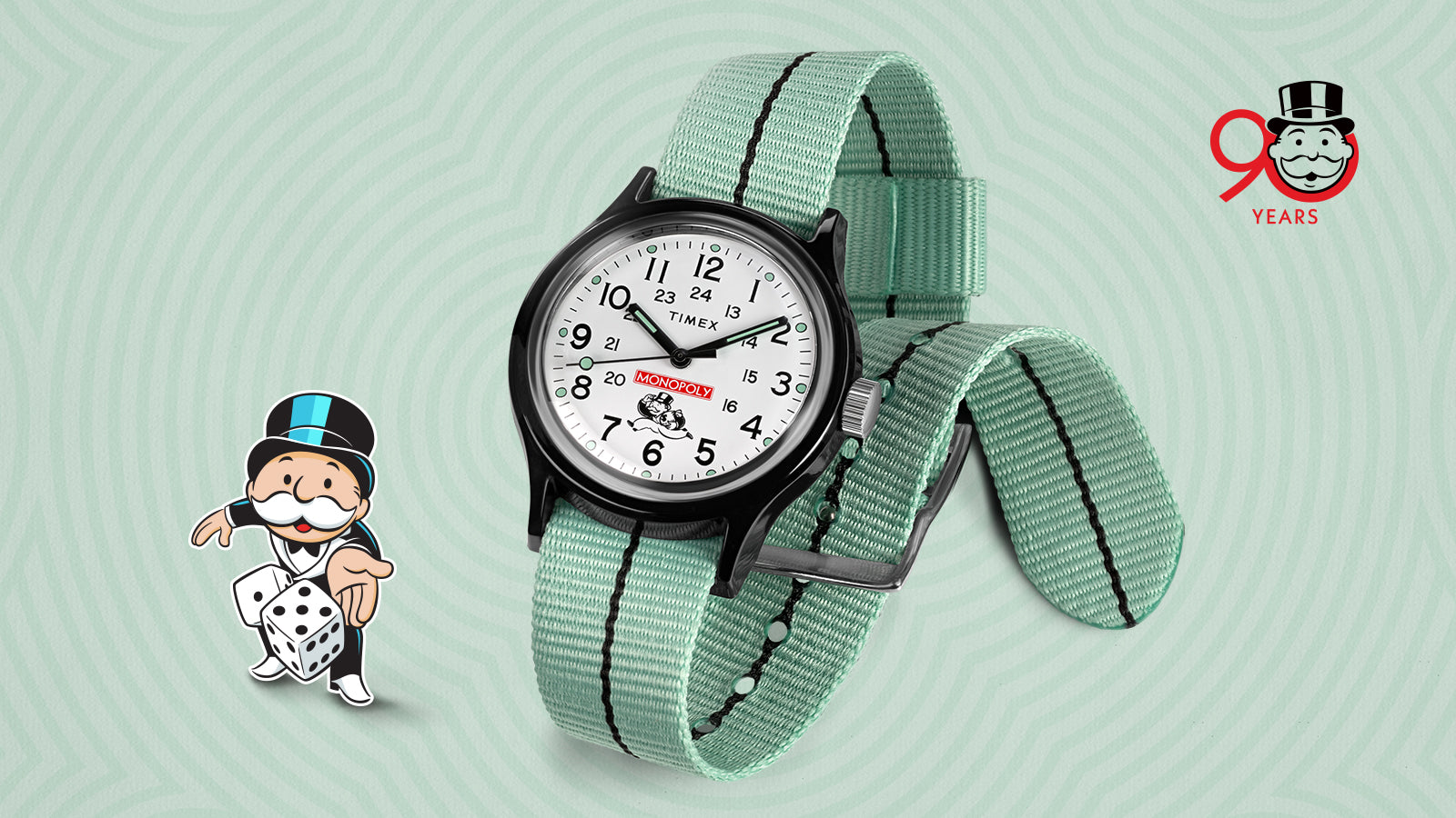 Angled shot of the Timex x Monopoly MK1 watch with the Monopoly mascot holding dice beside it, celebrating Monopoly’s 90th anniversary. The watch features a white dial, black case, and mint-green strap with black accents against a patterned mint background.