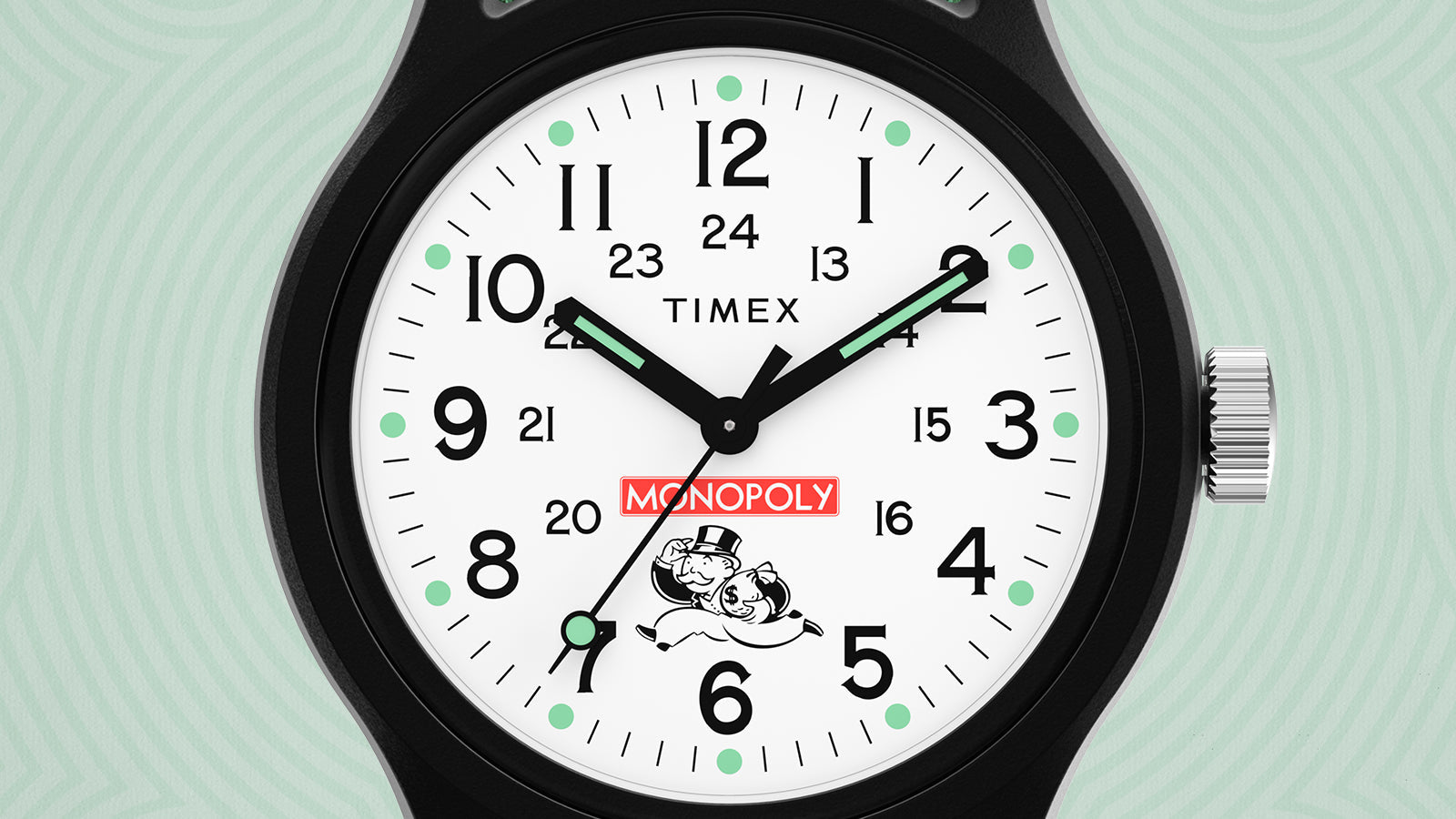 Close-up of the Timex x Monopoly MK1 watch dial showing bold black hour markers, luminous mint-green dots, and the red Monopoly logo. The Monopoly mascot, Rich Uncle Pennybags, runs below the logo holding a bag of money. The watch hands are luminous with a black frame.