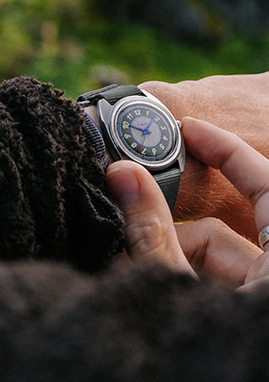A close-up of the gray strap on the Timex x Worn & Wound Storm, showing stitching, keepers, and texture against a rope background.