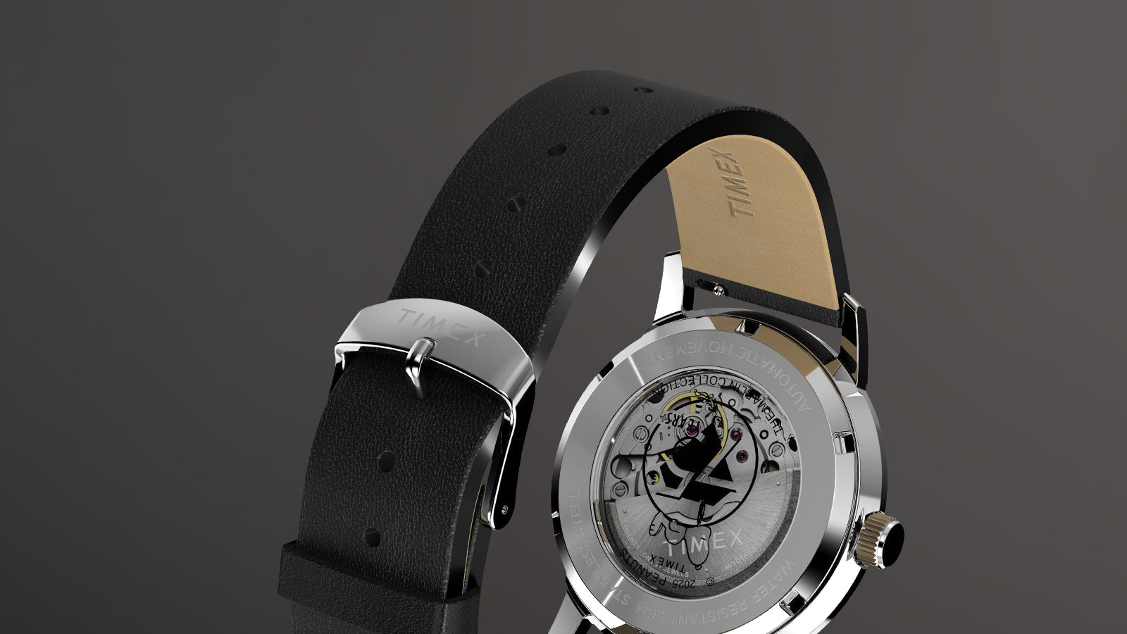 Rear view of the Timex x Peanuts® Marlin® Automatic 75th Anniversary Edition showing its textured black leather strap and polished silver buckle engraved with the Timex logo. The exhibition caseback showcases the 75th anniversary Peanuts logo on the rotor.