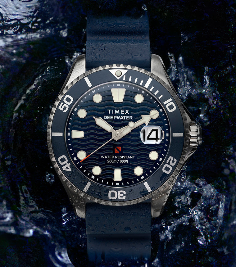 Timex Deepwater Meridian 200 dive watch with blue strap and wavy blue dial surrounded by splashing water, emphasizing its rugged 200-meter water resistance.