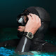 Freediver adjusting diving mask while wearing the Timex Deepwater Reef 200 Titanium Automatic watch, showing rugged titanium case and rubber strap in aquatic setting.