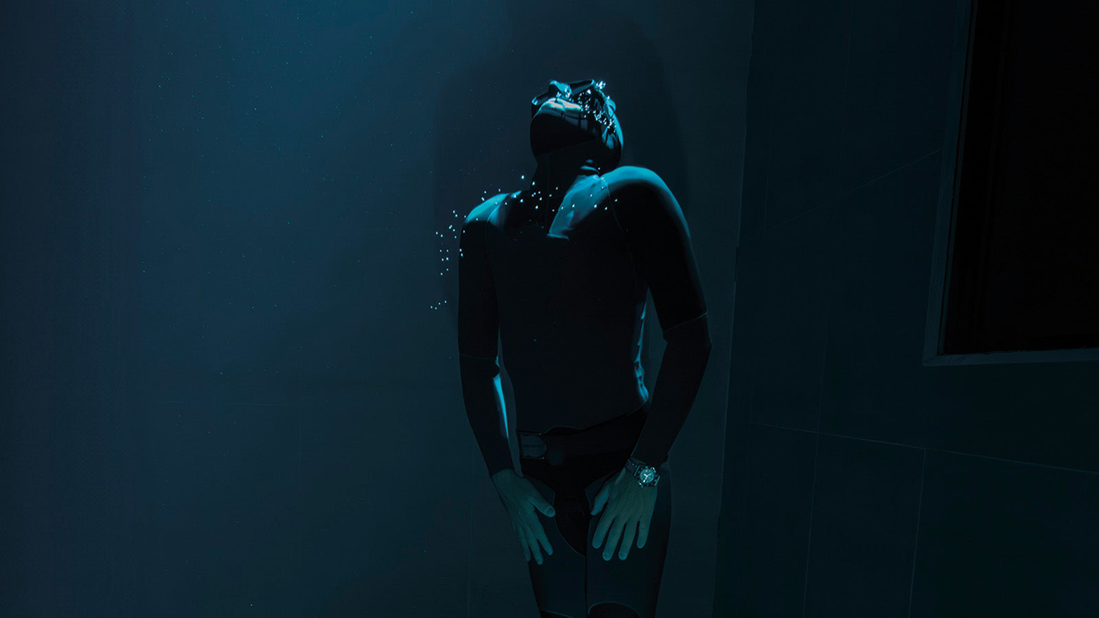 Underwater shot of a freediver wearing the Timex Deepwater Reef 200 Titanium Automatic watch, surrounded by deep blue light and air bubbles, showcasing dive-ready performance.