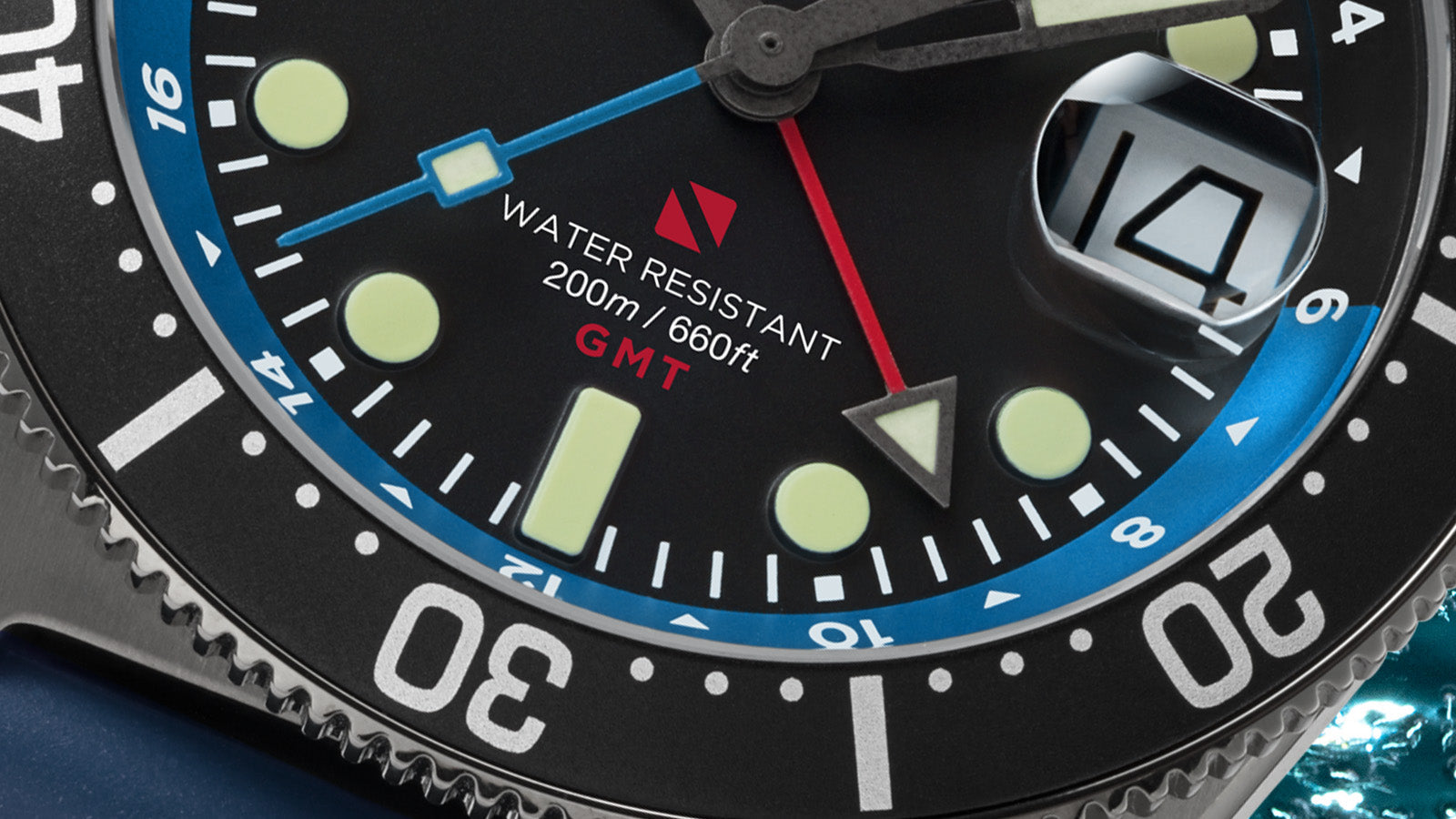 Macro close-up of the Timex Deepwater Reef 200 GMT dial highlighting the blue GMT hand, red “Water Resistant 200m / 660ft” text, and detailed bezel engravings.