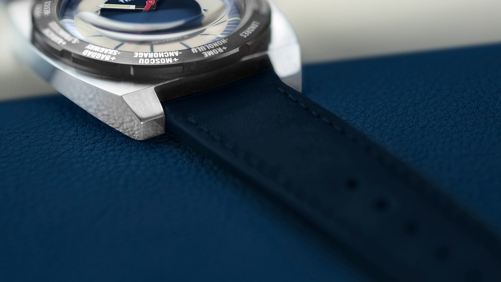 Macro view of the Q Timex® 1972 World Time focusing on the textured navy strap and polished case edge, emphasizing craftsmanship and detail.