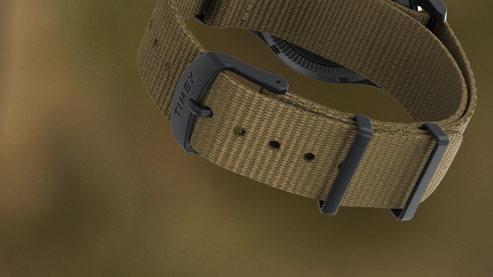 Close-up of the khaki fabric strap of the Timex Expedition Field Post Solar watch, showing black buckle engraved with “Timex” and durable stitching detail.