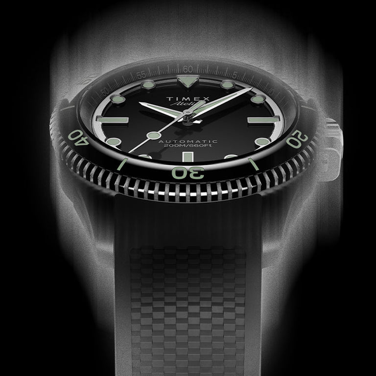 Front view of the Timex Atelier automatic dive watch with black dial, luminous indices, and black textured rubber strap, designed for mobile display.