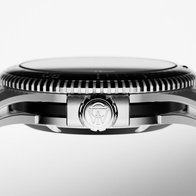 Profile shot of the Timex Atelier stainless steel case, focusing on the engraved crown with Timex “T” emblem and finely notched bezel.