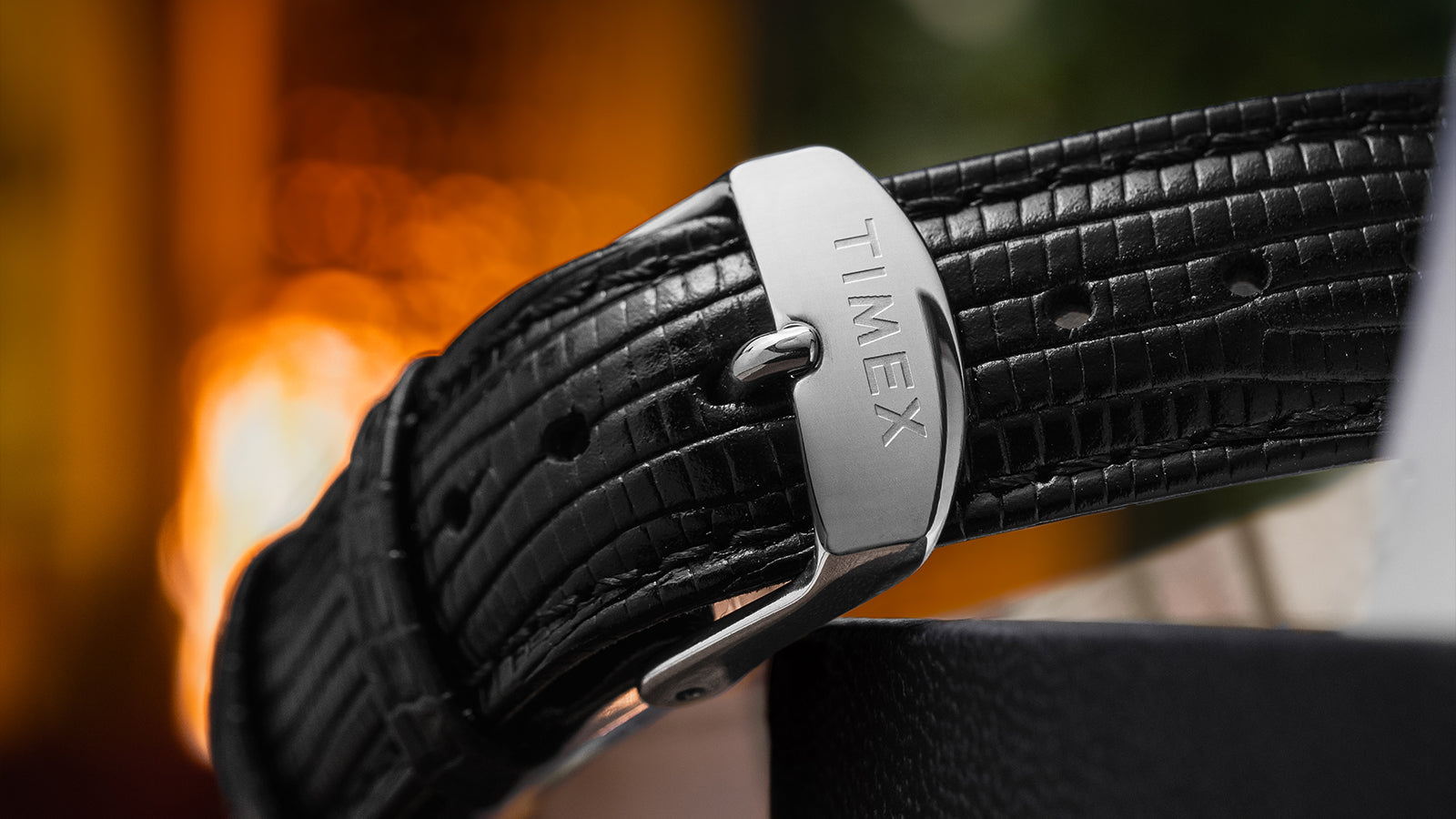 Macro image of the Timex-branded stainless steel buckle on the black lizard-pattern leather strap of the Timex Marlin Hand-Wound watch.