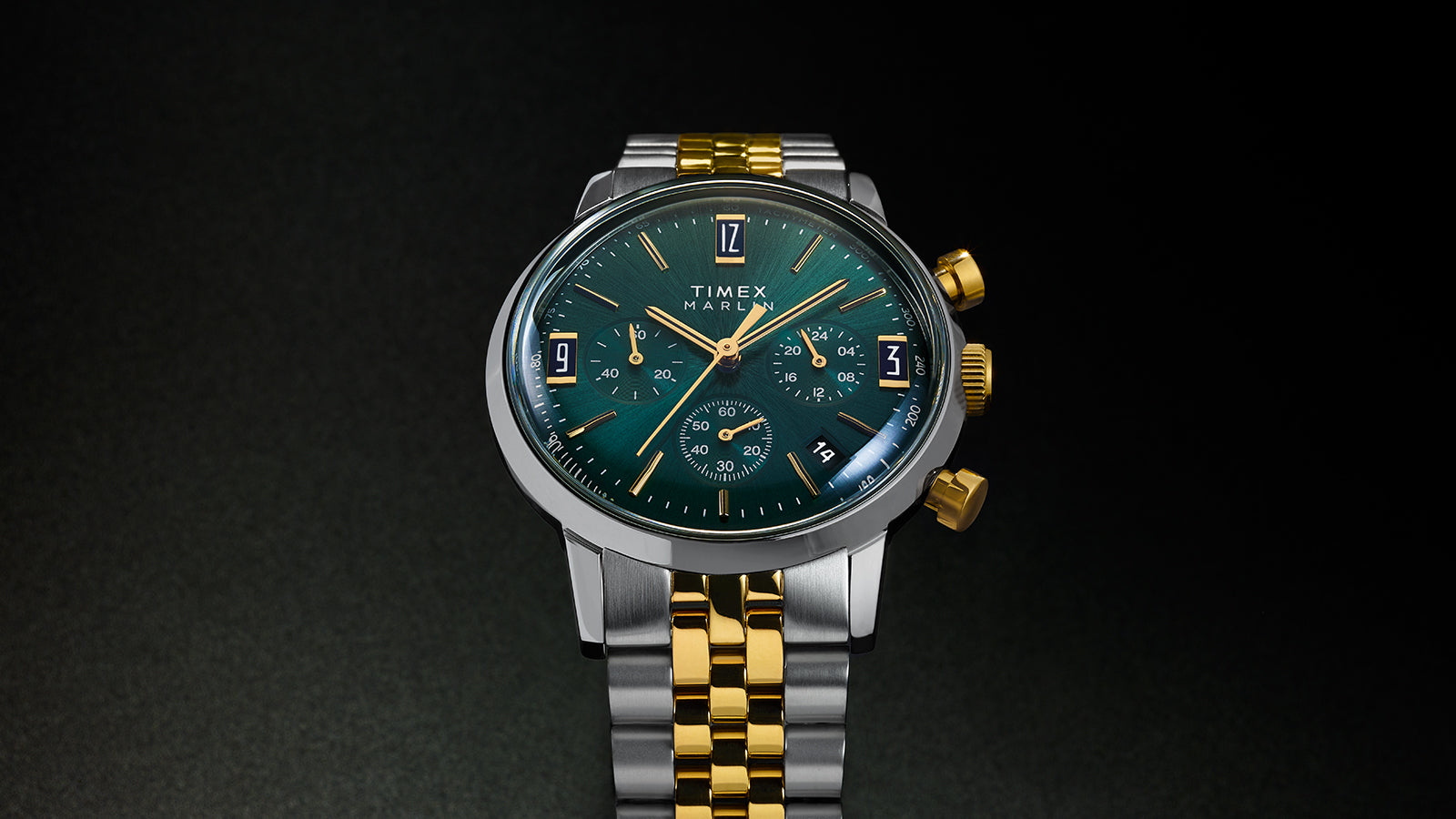 Front view of Timex Marlin Chronograph Tachymeter showcasing deep green dial with gold-tone hands and markers, and two-tone bracelet.