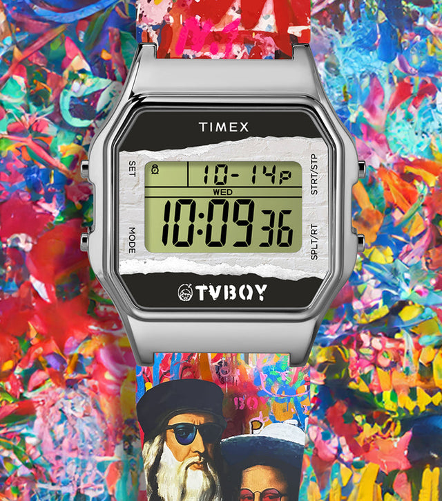 Timex T80 x TVBOY digital watch with a colorful graffiti-style strap and a silver-tone rectangular case. The LCD display shows the Timex and TVBOY logos, set against a vivid, abstract background of layered spray-paint art symbolizing street creativity and modern culture.