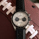 Timex Waterbury Heritage Chronograph placed on a textured football, highlighting its sporty black bezel, dual sub-dials, and perforated leather strap.