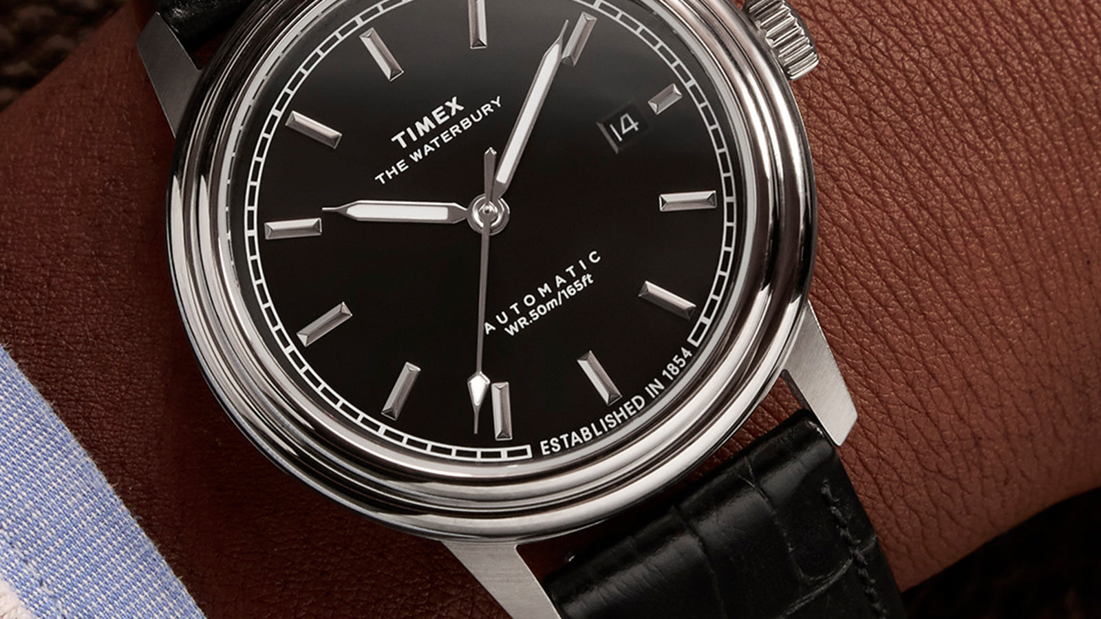 Close-up of the Timex Waterbury Metropolitan Automatic black dial with applied markers, polished hands, and date display at 3 o’clock.