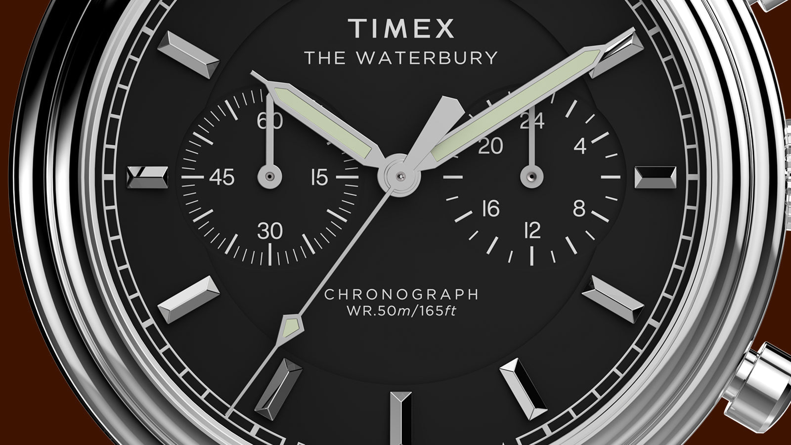 Close-up of the Timex Waterbury Metropolitan Chronograph black dial showing chronograph sub-dials, luminous hands, and silver indices.