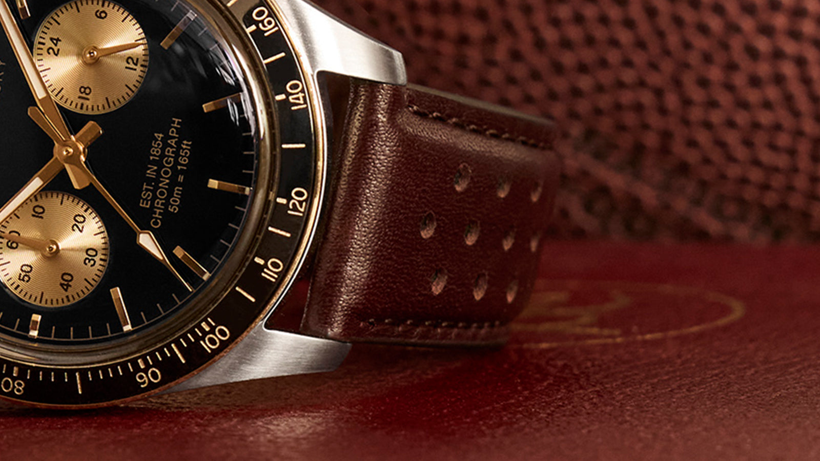 Close-up of the Timex Waterbury Heritage Chronograph brown perforated leather strap with gold-tone case detail.