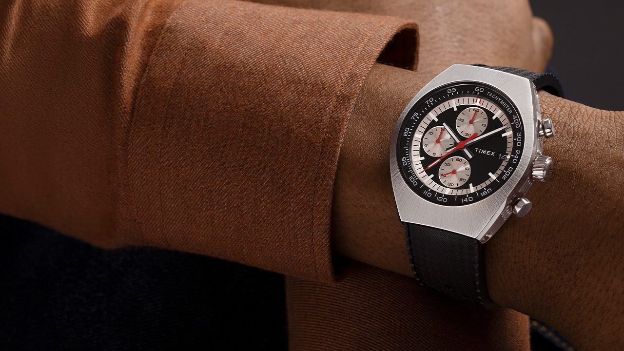 TIMEX® Legacy Tonneau Chronograph worn with a brown jacket, showing its bold tonneau-shaped case and sporty chronograph subdials.