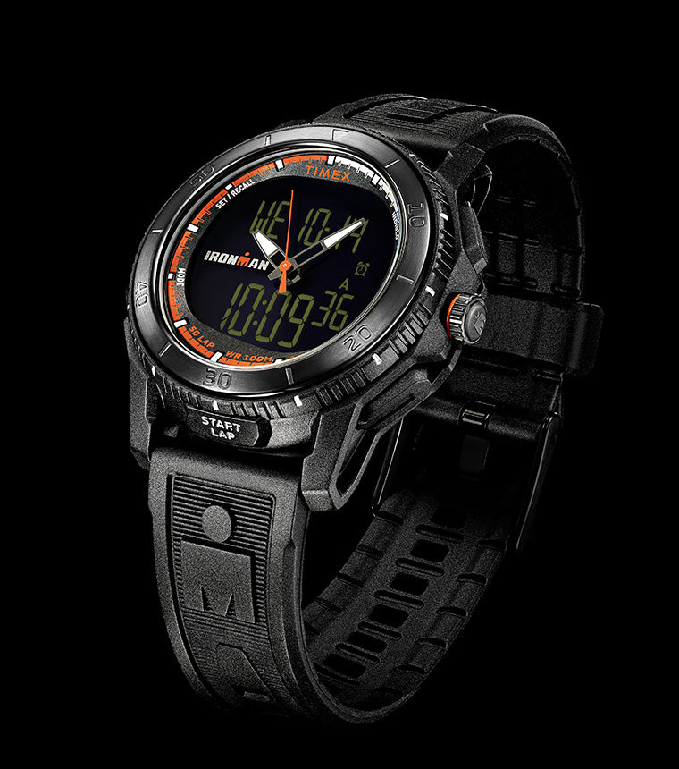 TIMEX® IRONMAN® Adrenaline Ana-Digi watch with black resin case, orange accents, and dual analog-digital display shown against a solid black background.