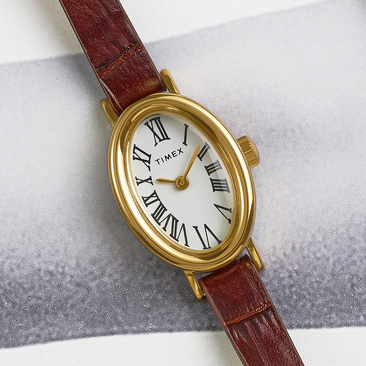 Top view of the TIMEX® Cavatina watch showing its classic white dial with black Roman numerals and gold-tone hands.