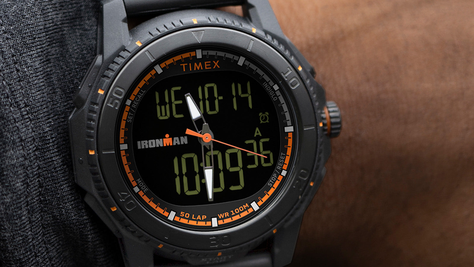 Close-up of the TIMEX® IRONMAN® Adrenaline Ana-Digi watch dial on wrist, highlighting day, date, and time display with orange chronograph accents.