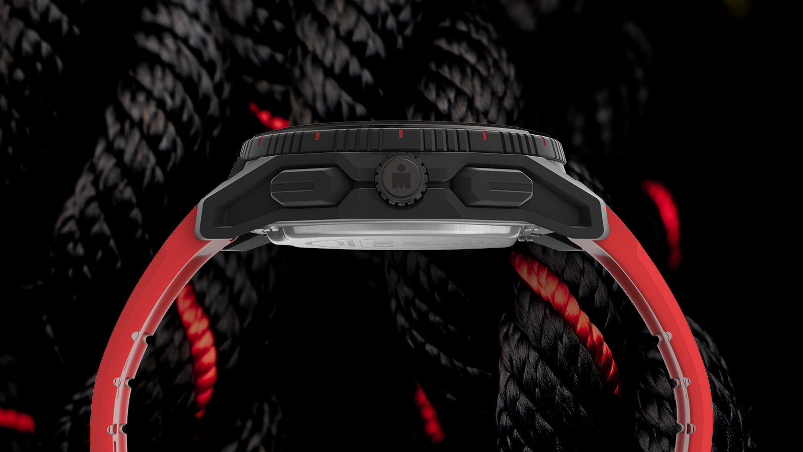 Profile view of the TIMEX® IRONMAN® Adrenaline Ana-Digi watch showing the textured crown and red silicone strap against black rope background.