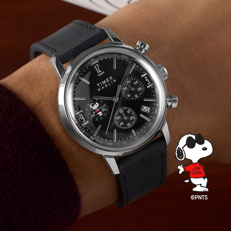 Peanuts® x Timex Marlin® Chronograph watch with black dial, leather strap, and Snoopy “Joe Cool” subdial detail worn on wrist.