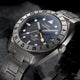 Close-up angled view of the Expedition® Pioneer Titanium Automatic GMT highlighting the black dial, luminous hour markers, date window, and yellow GMT hand.