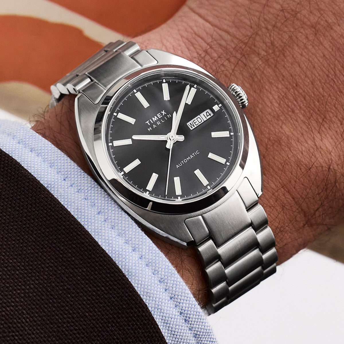 Timex Marlin Draper Automatic watch worn on the wrist, showing a black dial, day-date window, and stainless steel bracelet.