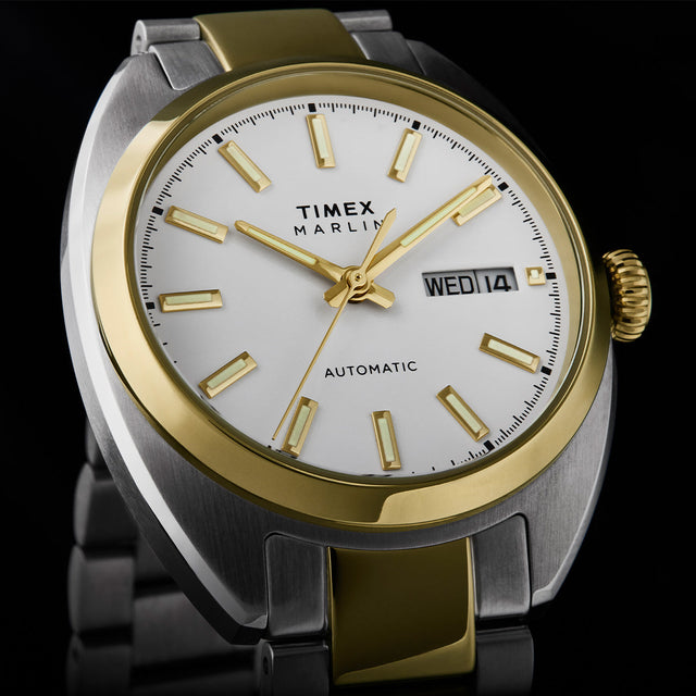 Close-up of the Timex Marlin® Draper Automatic white dial with gold-tone hands, luminous hour markers, and day-date display.