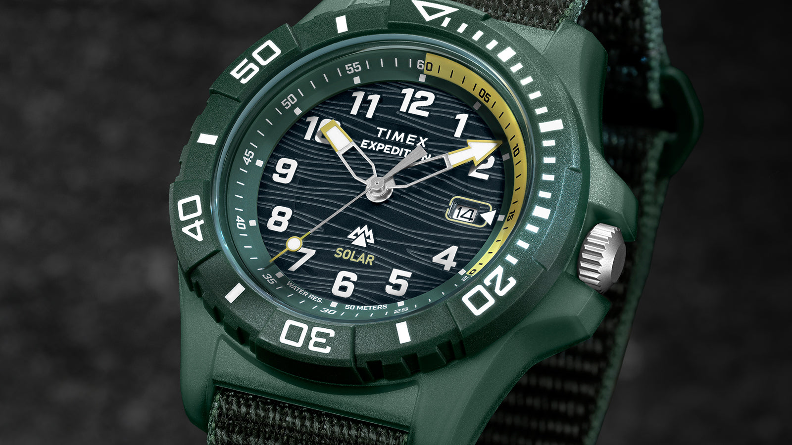 Timex Expedition® Freedive Solar watch with green resin case, black dial, yellow accents, and 50-meter water resistance on dark background.