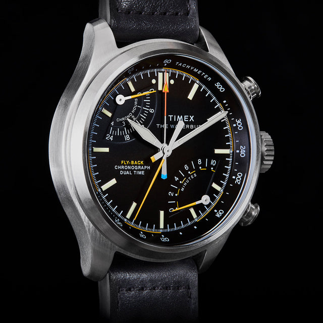 Close-up of Timex Waterbury Ace Fly-Back Chronograph black dial showing subdials, tachymeter scale, and luminous hands