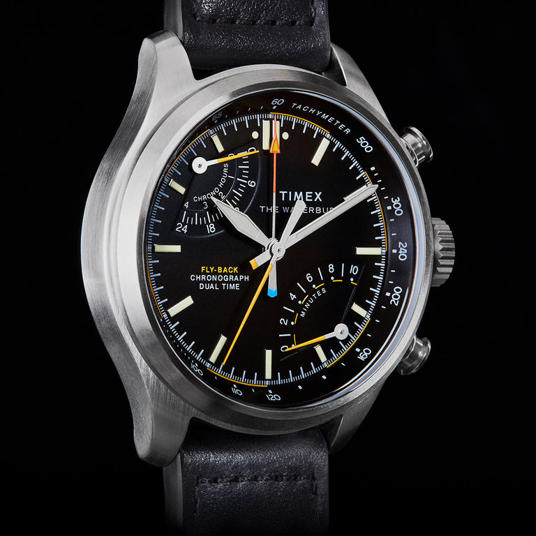 Close-up of Timex Waterbury Ace Fly-Back Chronograph black dial showing subdials, tachymeter scale, and luminous hands