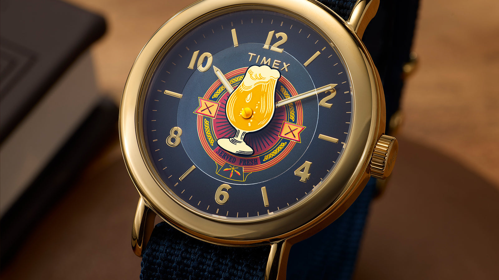 Detailed view of Harry Potter x Timex Weekender Butterbeer dial with gold numerals and Butterbeer emblem.