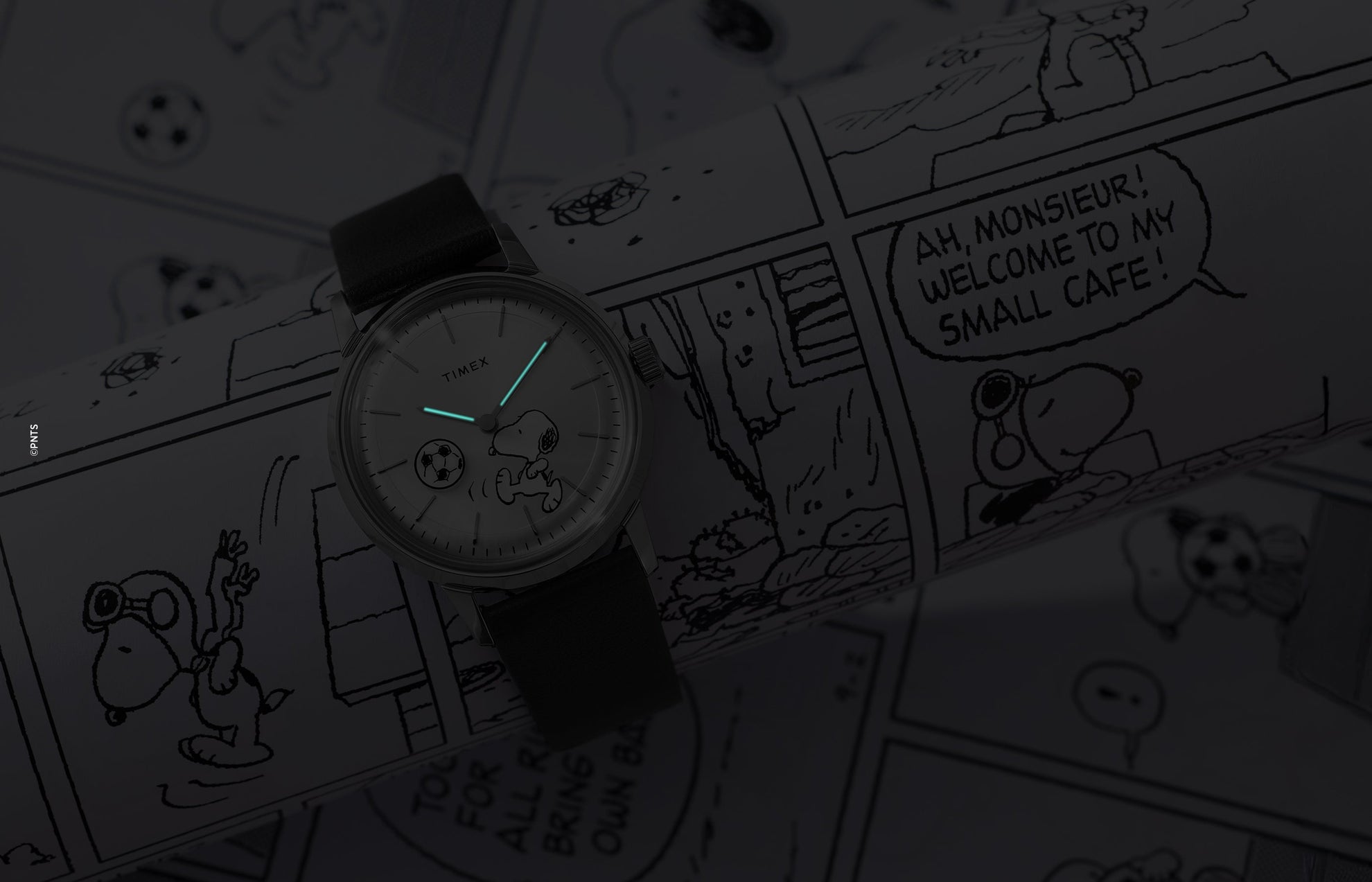 Timex Marlin Automatic Peanuts watch glowing in the dark showing luminous hands over Snoopy soccer dial