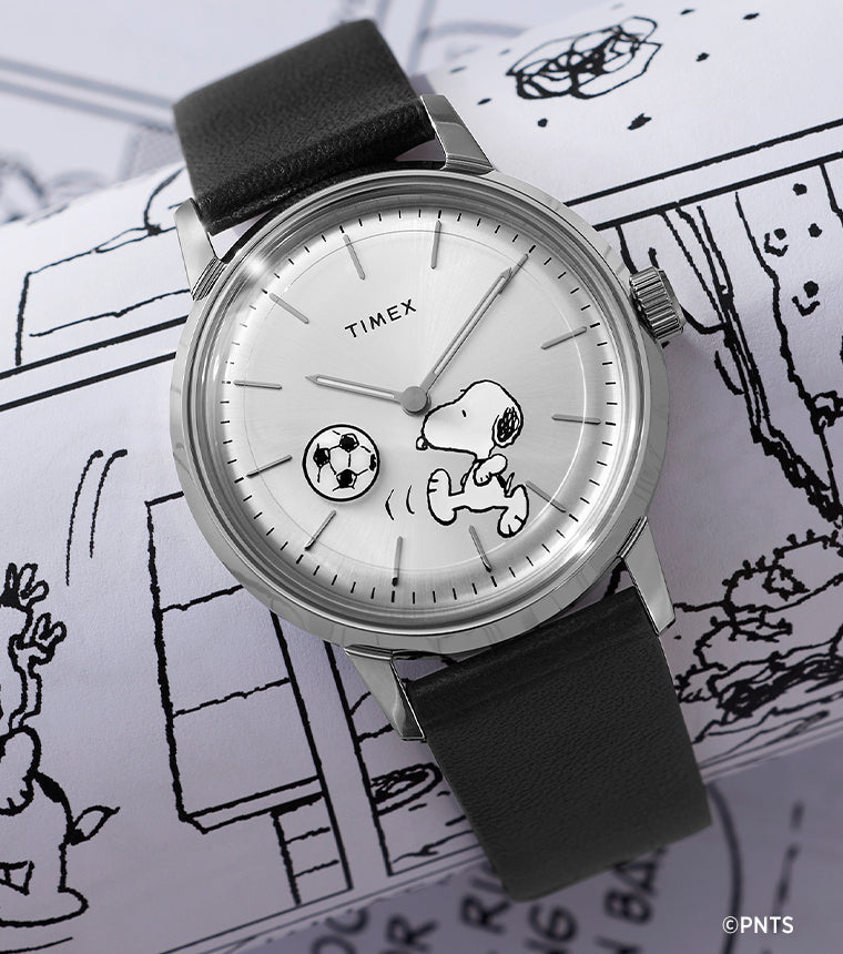 Timex Marlin Automatic x Peanuts watch with Snoopy soccer dial placed on black-and-white Peanuts comic strip background