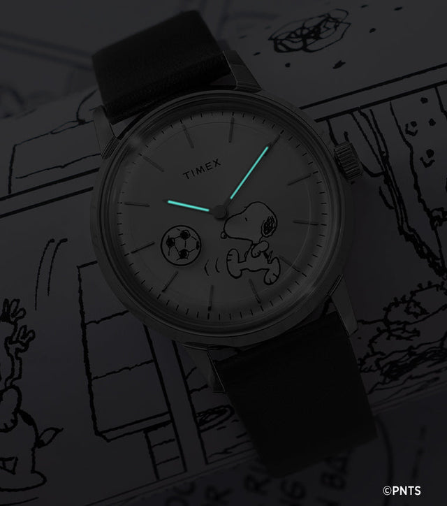 Timex Marlin Automatic Peanuts watch glowing in the dark showing luminous hands over Snoopy soccer dial