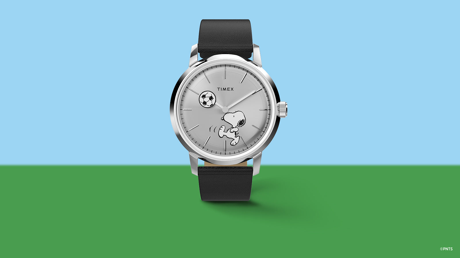 Timex Marlin Automatic x Peanuts Snoopy soccer watch with silver dial and black leather strap on blue and green background